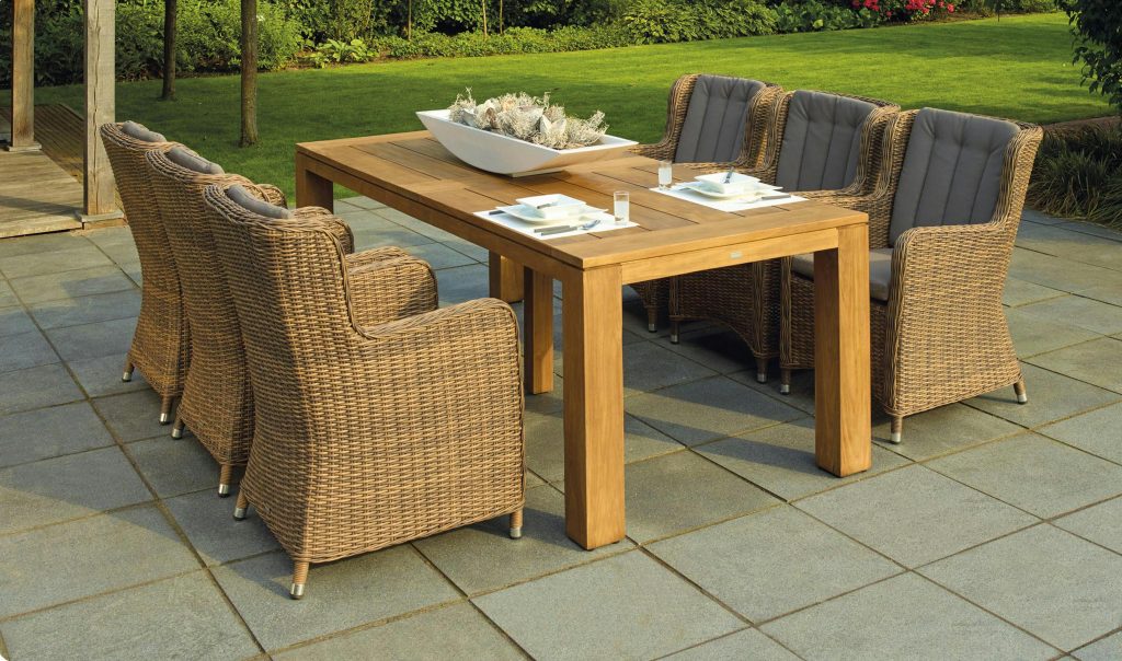 pexels-photo-238377-238377 A serene outdoor patio set up with rattan chairs and a wooden table, perfect for relaxation.